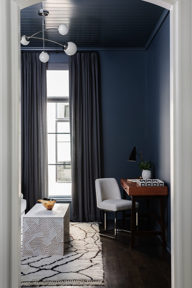 Modern Bedroom Design with Deep Blue Walls and Palm Leaf Pillows