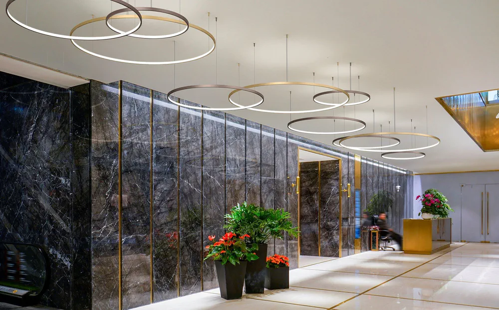 Modern Lobby Design with Circular Pendant Lights and Marble Wall