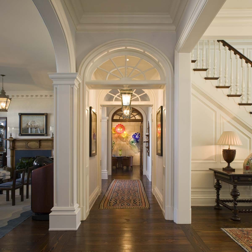 Classical Hallway Design with Red Carpet and Architectural Columns